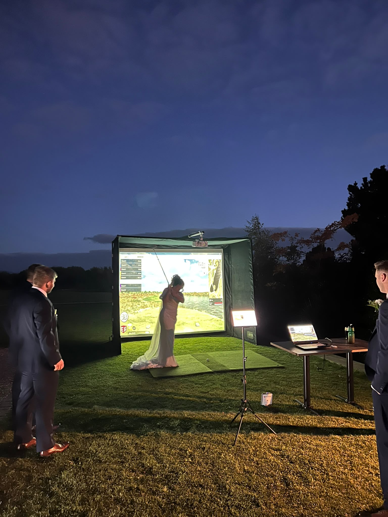 Bride playing golf in her wedding dress at an evening reception
