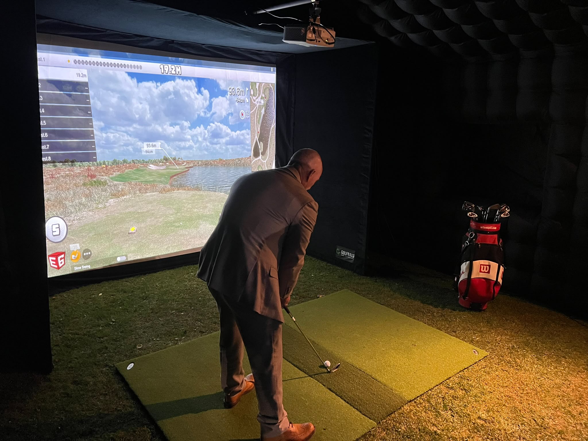 Guest lining up a golf shot inside our inflatable simulator enclosure
